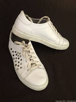 Pair of white leather Boemos shoes, size 7, showing flat side profile and stud detailing.