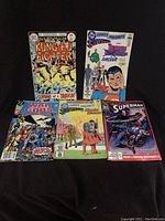 Lot of 5 DC Comics comic books including Richard Dragon Kung-Fu #1, DC Comics Presents #59 and #32, War Of The Gods #1, and Superman #49, all arranged on black background