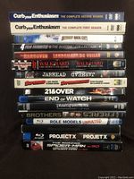 Photo shows collection of DVDs and Blu-Rays stacked vertically with spines visible. Titles include Curb Your Enthusiasm seasons 1 and 2, Detroit Rock City, The Matrix collection, Walk Hard, Jarhead, Supernova, 21 & Over, End of Watch, Transformers, Brothers, Role Models unrated, Project X, and The Amazing Spider-Man Spider-Man Edition.