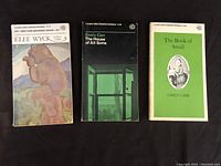 Three paperback books by Emily Carr displayed flat: Klee Wyck with a colorful bear illustration, The House of All Sorts with a dark green window photo cover, The Book of Small with a green cover and portrait illustration.