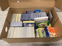 Card lots in cardboard box with various stacked cards