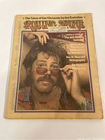 Front cover of the 1973 Rolling Stone Magazine featuring a man with glasses and mustache with colorful typography and article headlines.