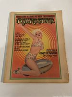 Front cover of the 1974 Rolling Stone magazine showing vintage illustration of a woman posing on a bomb with thematic text.