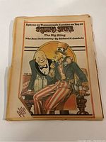 Front cover of a 1974 Rolling Stone magazine featuring an illustrated image of Uncle Sam and a man seated at a table with bottles labeled GAS and other items.