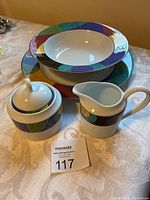 Full set showing serving bowl, platter, cream pitcher, and sugar bowl with lid arranged on a fabric surface