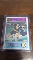Front of 1975-76 Bobby Orr NHL hockey card showing player in Boston Bruins uniform with NHL First Team All-Stars heading.