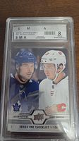 Clear image of the graded and autographed hockey card featuring Auston Matthews and Johnny Gaudreau.