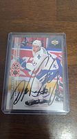Front image of Peter Forsberg hockey card showing the player in Quebec Nordiques uniform with autograph across the card, housed in protective plastic.