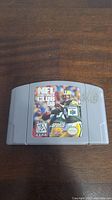 Front view of NFL Quarterback Club 98 N64 cartridge showing game label with player image and logos.