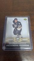 Front view of Sidney Crosby rookie card showing player in Pittsburgh Penguins uniform, card titled 'Phenomenal Beginning'