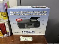 Photo of the original retail box for Cambridge SoundWorks compact stereo system detailing features like CD player, FM stereo, AM reception, and powered subwoofer.
