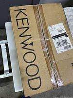 Closed Kenwood branded cardboard packaging for KT-595 tuner showing original shipping labels.