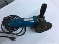 Blue Chicago Electric angle grinder with power cord coiled beside it