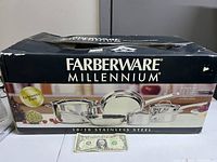Farberware Millennium 8-piece stainless steel cookware set in original boxed packaging with images of pots and pans on the box front.