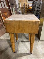 Front view of butcher block table showing overall structure and condition