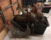 Photo of metal-framed lighted deer and sleigh inside a black plastic storage tote; deer bodies visible with detailed wire mesh design.