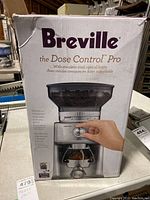 Front of the original Breville box showing the Dose Control Pro coffee grinder image, brand name, and features in English and French.