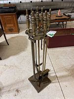 Full view of the fireplace tool set on stand showing brass finials and four tools.
