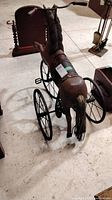 Full view of vintage horse tricycle showing body, wheels and handlebars.
