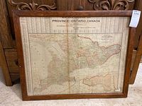 Full view of framed map with wooden frame and visible scratches on frame edges.