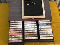 Cassette tapes lot with some titles visible, including ABBA tapes and classical music collections, arranged in a black cassette case.