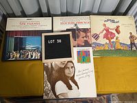 Four movie music albums laid out on a yellow surface, showing covers of The Mikado, Doctor Zhivago, The Sound of Music, and Love Story.