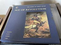 Top view of the closed boxed set showing the blue slipcase with gold lettering and historic painting on cover