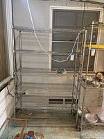 Front view of the six-shelf metal wire shelving unit in a storage area.