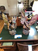 Front view of both carved wooden dragons side by side on table