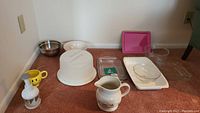 Full set of bakeware and kitchen storage items including plastic cake storage, mixing bowls, baking pans, Longaberger pitcher, Chefmate bowl, chopper.