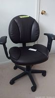 Front view of black leather padded swivel office chair with armrests and five-wheel base.