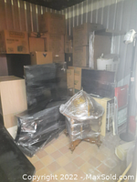 Shrink-wrapped glass TV stand and wooden globe bar with cardboard boxes