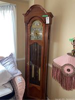 Full view of tall oak-finish Ridgeway grandfather clock in room