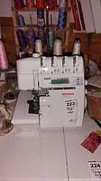 Front view of Bernina 1300DC serger showing brand, model label, tension dials and spool holders