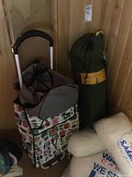 Photo showing pull cart with colorful fabric bag and canvas chair bag to the right.