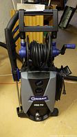 Front view of the Kobalt power washer showing the hose reel, handle, and base.
