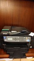 Epson ET-45550 black multifunction printer showing front control panel with LCD and buttons.