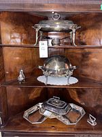 Photo of entire set showing multiple silver-plated serving ware pieces including chafing dish, trays, salt and pepper shakers with tarnish visible.
