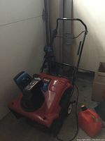 Front view of Toro snow blower with gas can alongside
