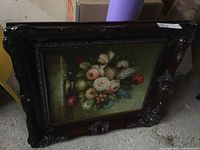 Overall view of framed floral still life oil painting showing carved wood frame and canvas artwork