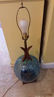 Full view of lamp showing blue glass globe, wood accent and bulb
