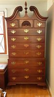 Front view of entire high chest showing pediment, drawers, hardware and finish