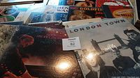 Several vintage vinyl record albums laid out overlapping showing colorful and classic album covers with notable titles such as 'London Town' and 'Bach Live at Philharmonic'.