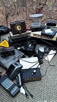 Photo showing various vintage electronics including vintage tube radio, switch panels, black amplifier, cables and connectors.