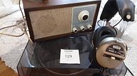Group photo showing the Nordmende headphones, wood cased radio, and black turntable together.