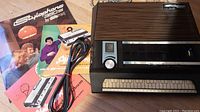 Overview of Stylophone 350S, power cable and three manuals laid out on table