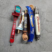 Photo showing 5 different used beer tap handles in varied shapes and brands.