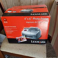 Original box of the Lexmark 4x6 photo printer showing brand and product details on the red and black packaging.