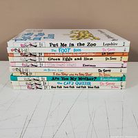 Stack of Dr. Seuss and related children's books with titles visible on spines, showing wear and some writing noted.