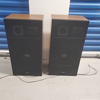 Pair of Toshiba SP-8 2-way speakers front view with grills on, wood grain finish, cords attached.